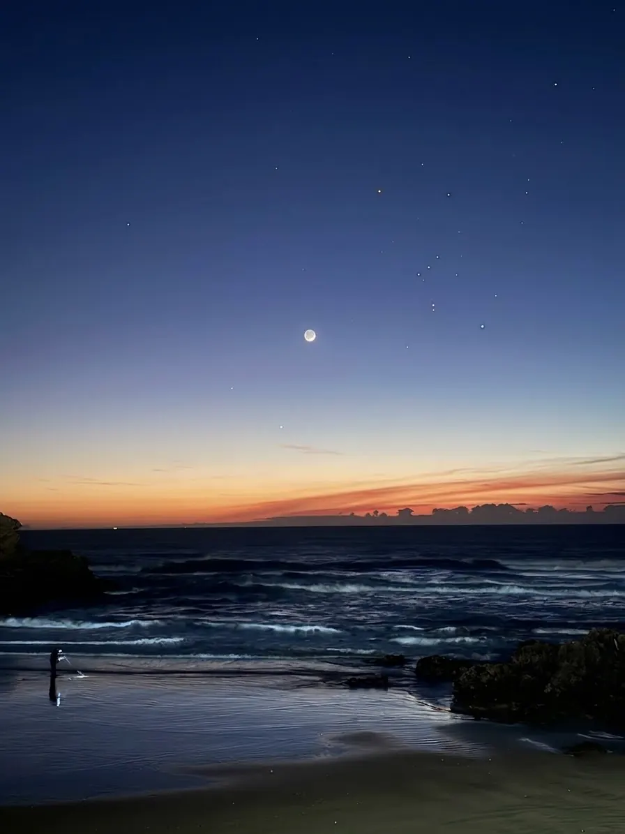 La lune et les premières étoiles au-dessus de l'océan
